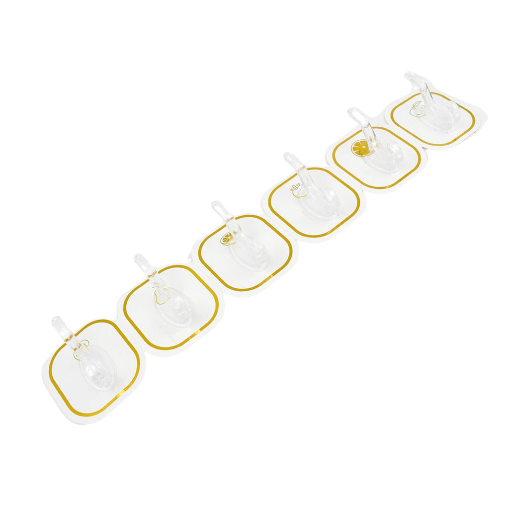 Six transparent adhesive hooks with gold borders arranged diagonally on a white background.