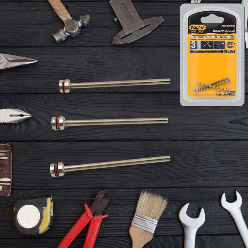 Three silver mandrels with red bands are laid out on a dark wooden background, alongside a product package and various tools.