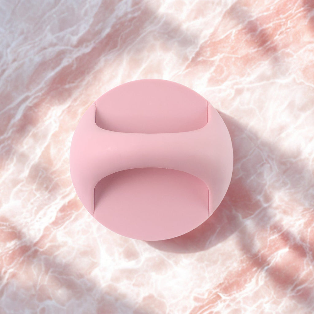 A pink self-adhesive handle is centered on a light pink marble background with soft shadows.