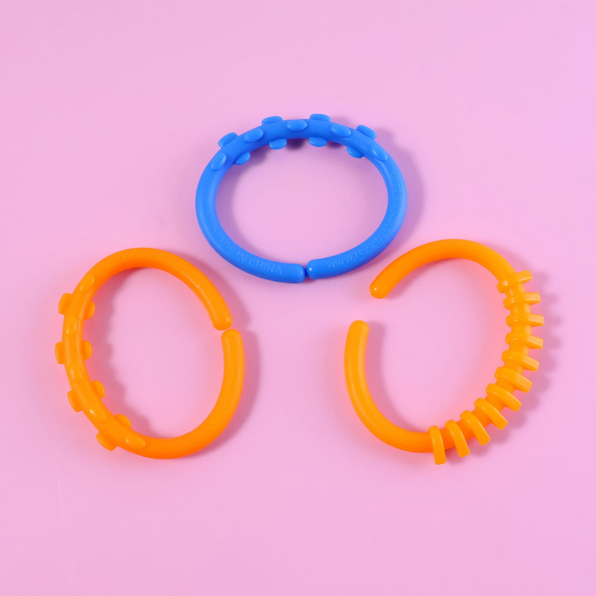Three separate orange and blue learning links with textured surfaces are arranged on a pink background.