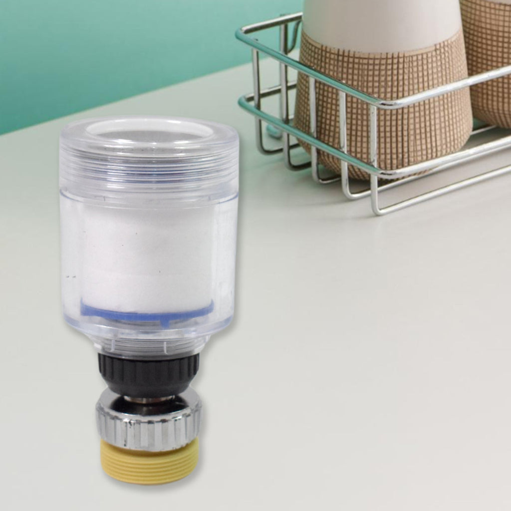A clear plastic swivel faucet aerator with a yellow base, standing upright on a white counter next to a dish rack.