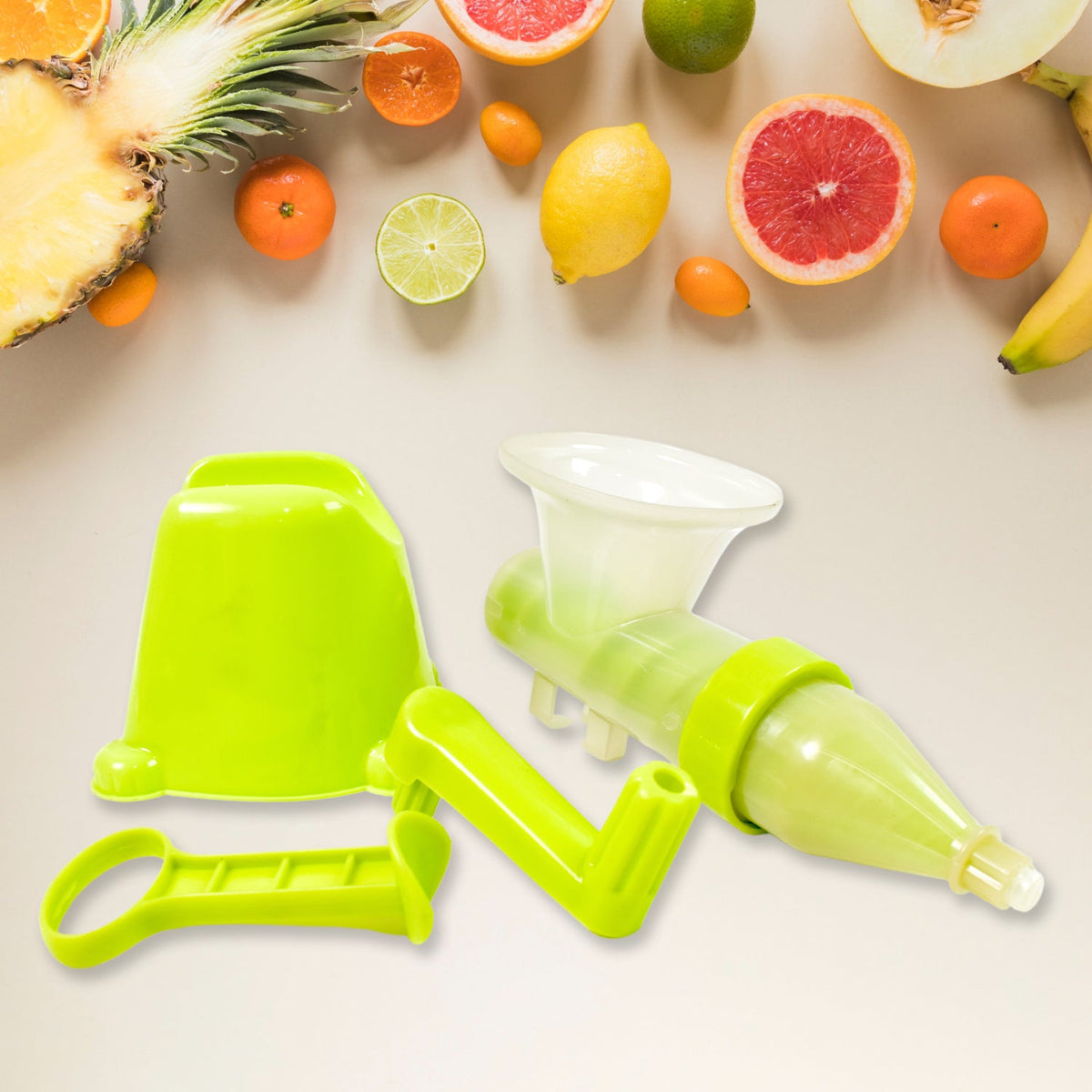 Disassembled green manual juicer parts, including the base, handle, and auger, surrounded by various fresh fruits.