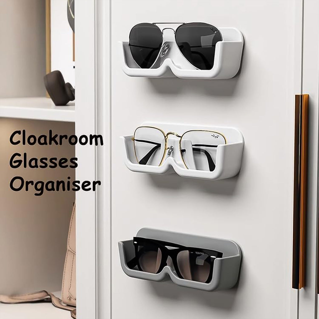 Three wall-mounted glasses holders, two white and one gray, holding different pairs of glasses on a white cabinet.
