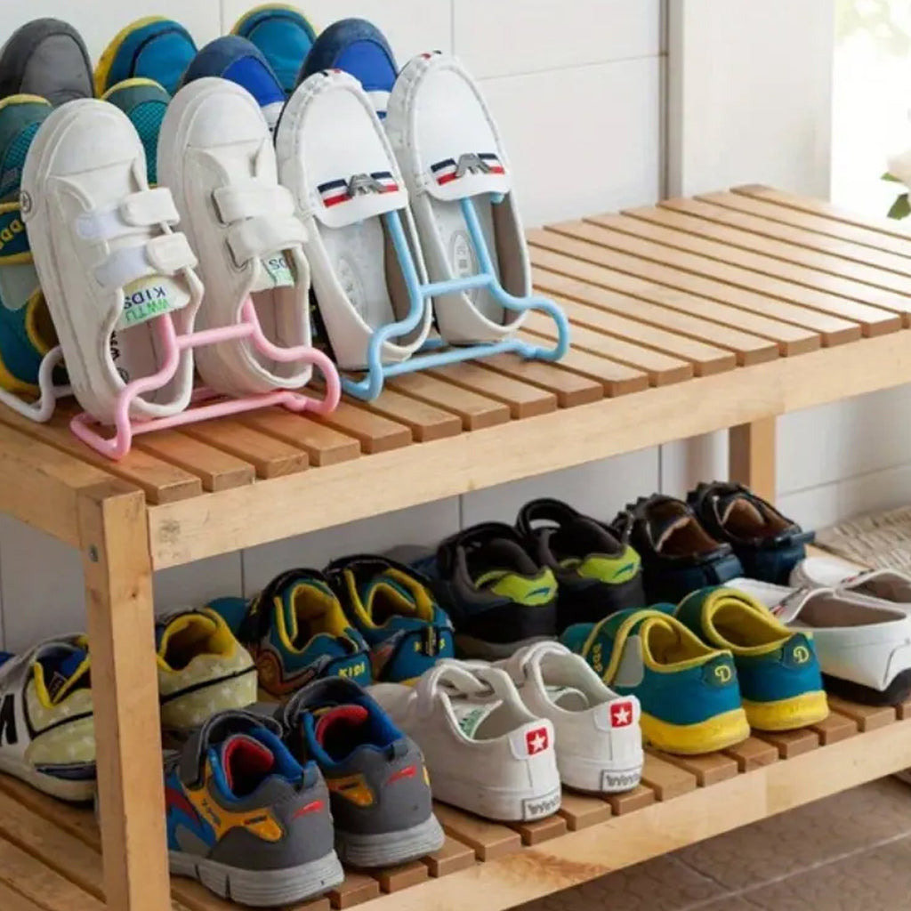 Several shoes are displayed on a wooden shoe rack, with some pairs hanging from pink and blue plastic hangers.