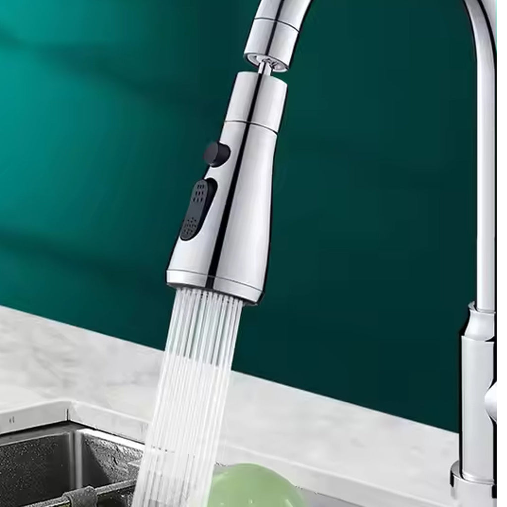 A chrome faucet sprayer head with black buttons sprays a strong stream of water into a sink with a green object.