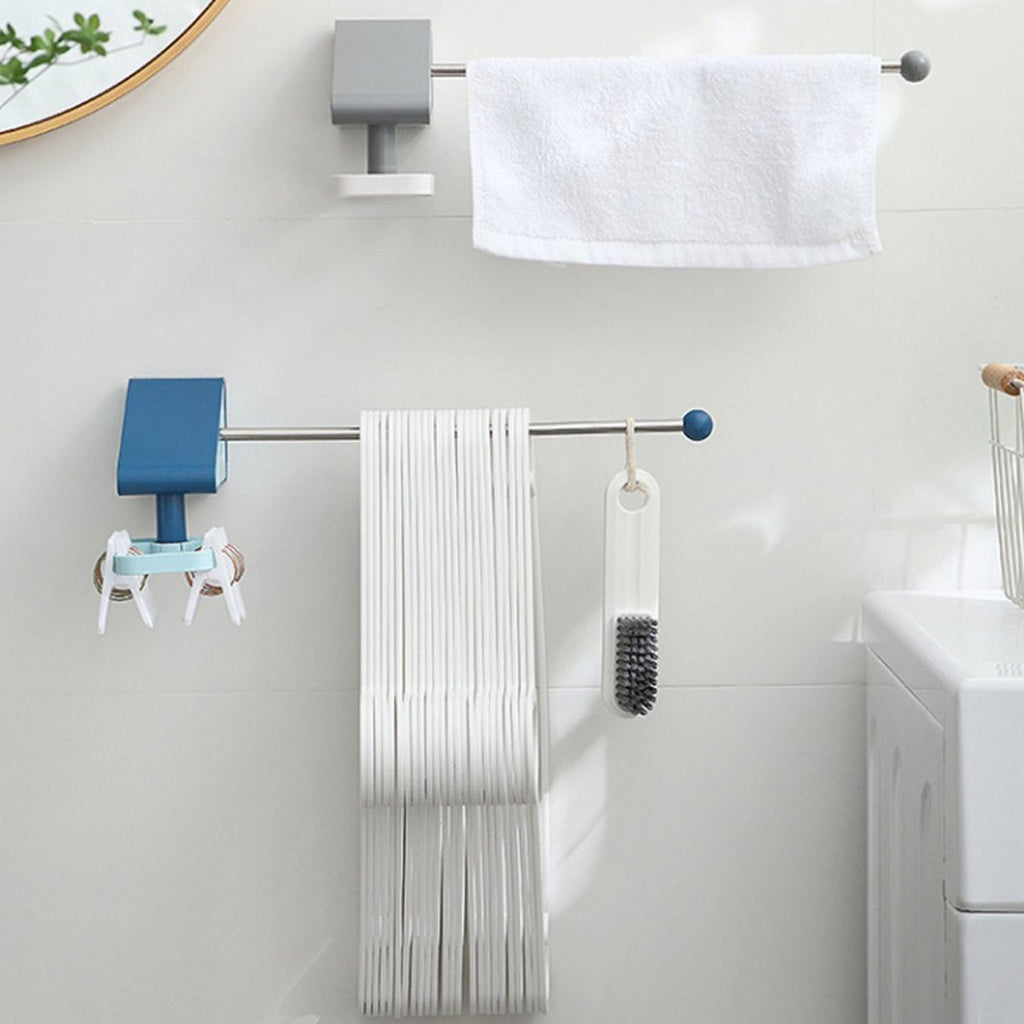 Two wall-mounted racks, one blue and one grey, holding hangers, keys, a brush, and a white towel in a bathroom.