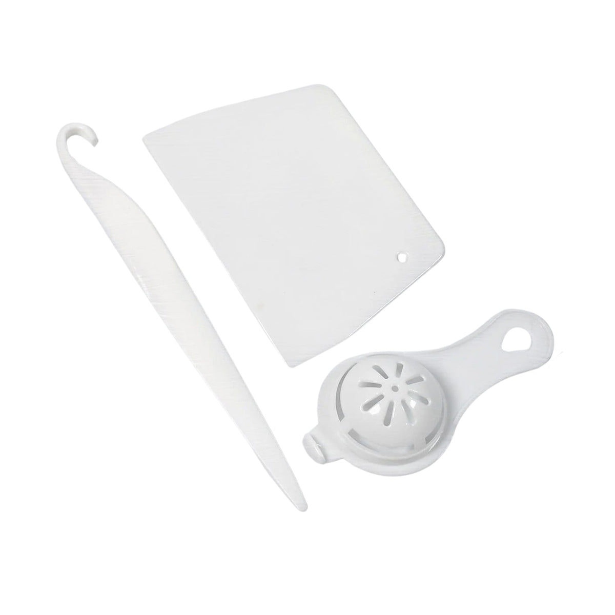 Three white plastic baking tools, including a scraper, a curved tool, and an egg separator, are arranged on a white