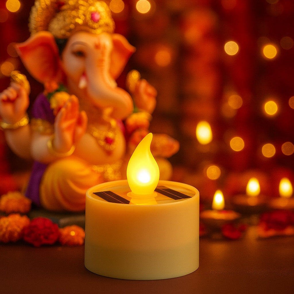 A glowing solar LED candle lamp in the foreground with a blurred Ganesha statue and bokeh lights in the background.