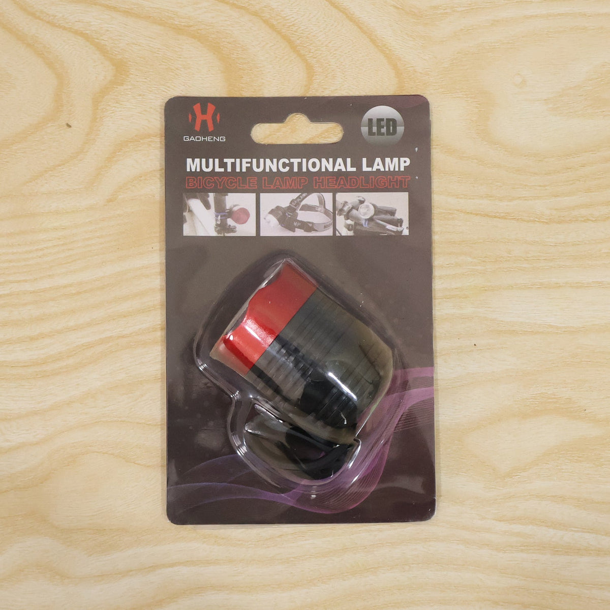 The red and black bicycle headlight is packaged in a clear plastic blister pack on a cardboard backing, labeled