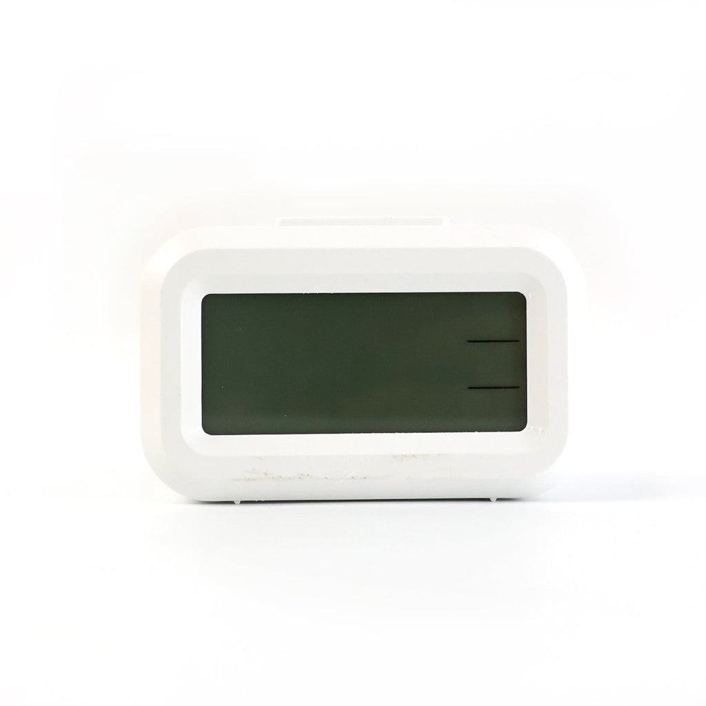 A white digital clock with a blank, dark rectangular screen is centered against a plain white background.