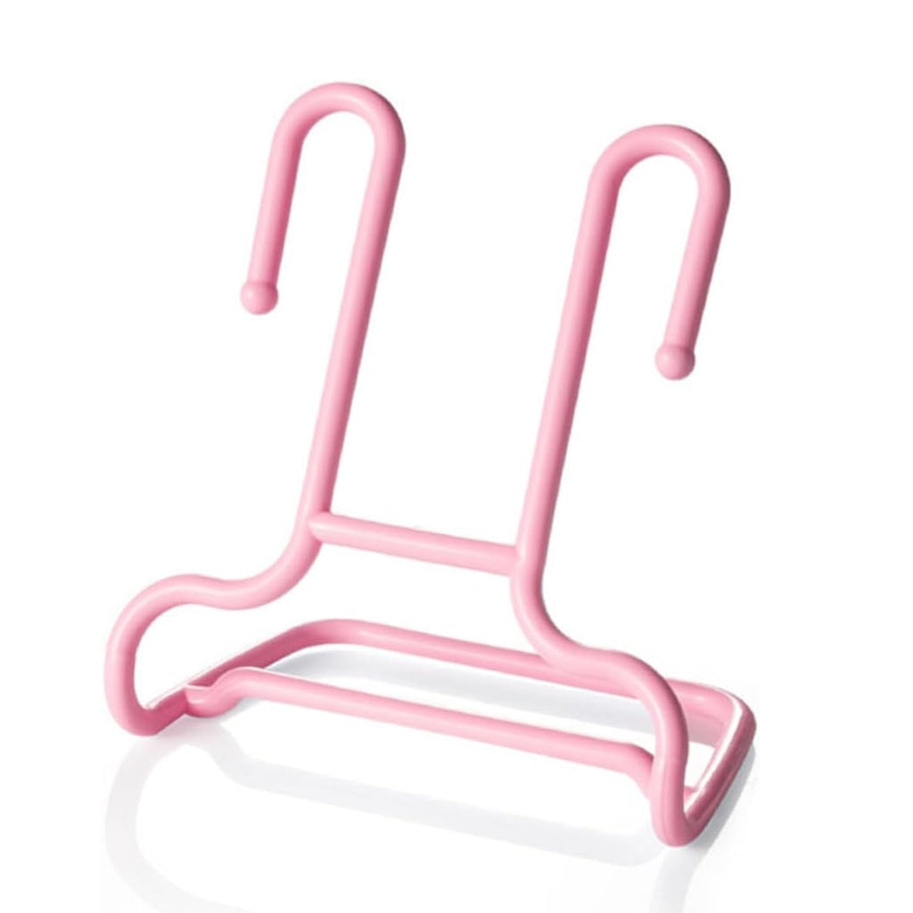 A single pink plastic shoe drying rack is shown on a reflective white surface.