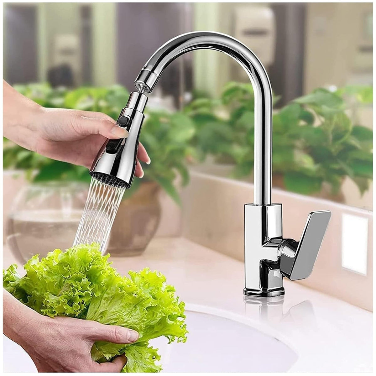 Hands hold lettuce under a chrome pull-down faucet sprayer head, with a modern chrome faucet in the background.