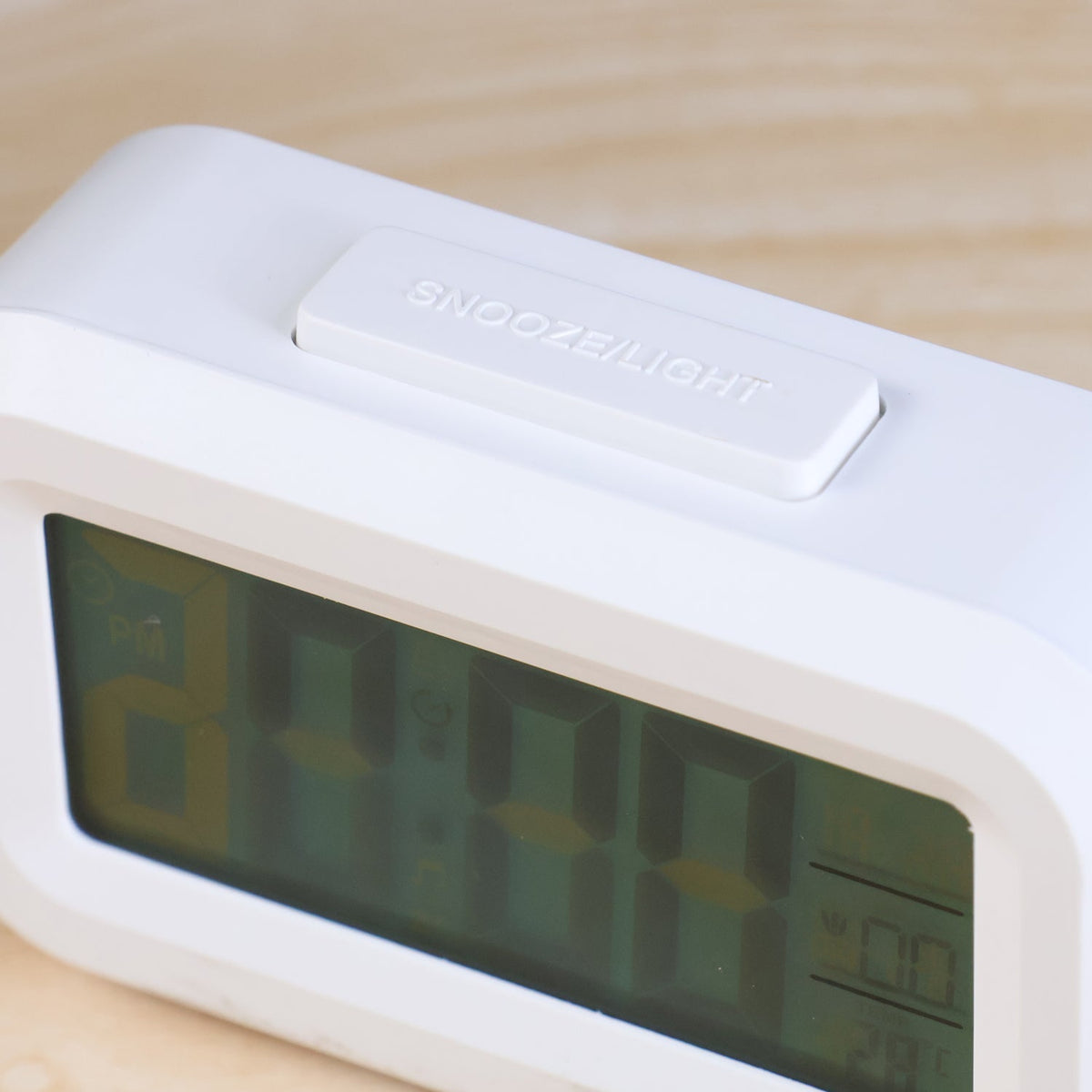 A close-up of a white digital clock shows the top