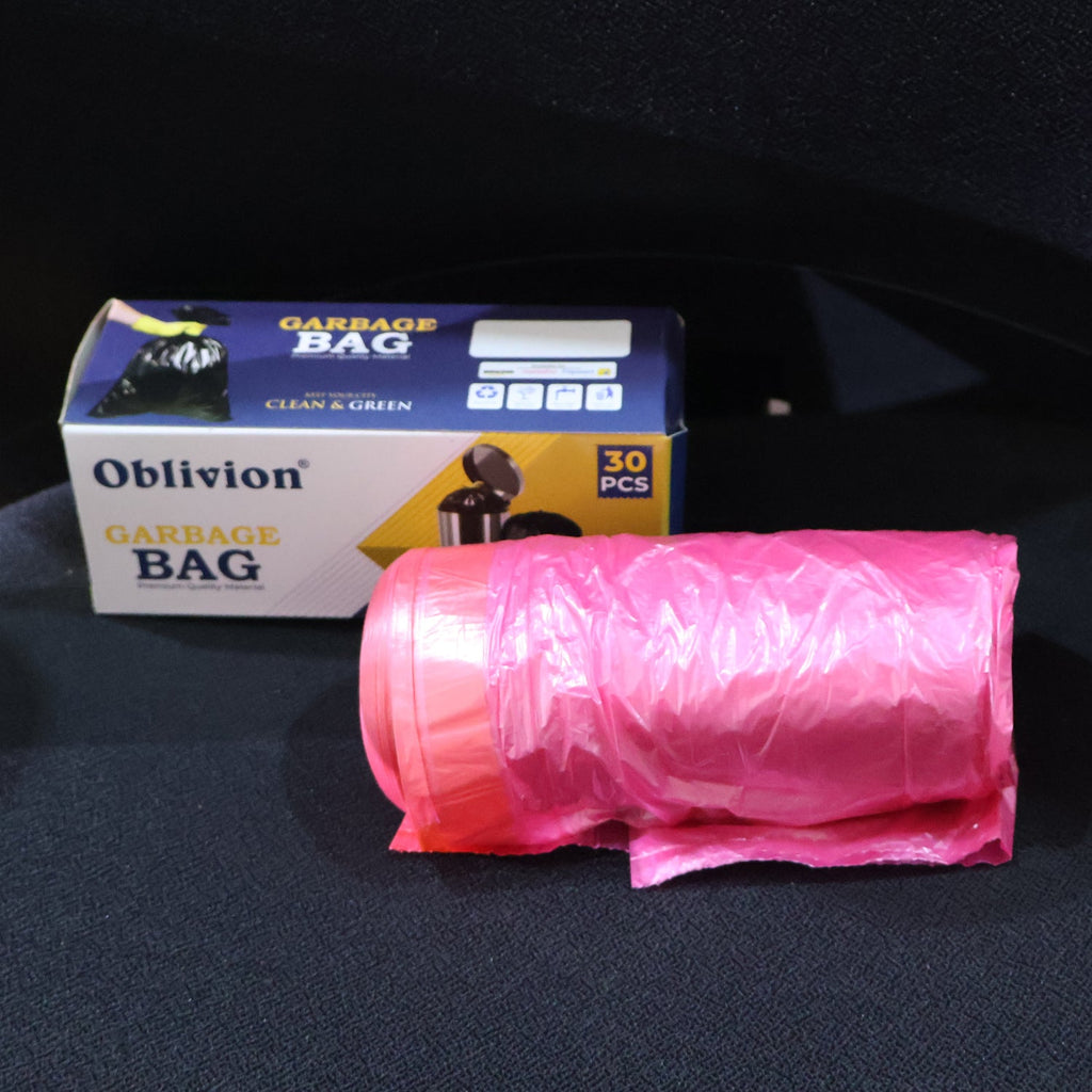 A roll of pink garbage bags next to a white box labeled "Oblivion Garbage Bag" on a dark surface.
