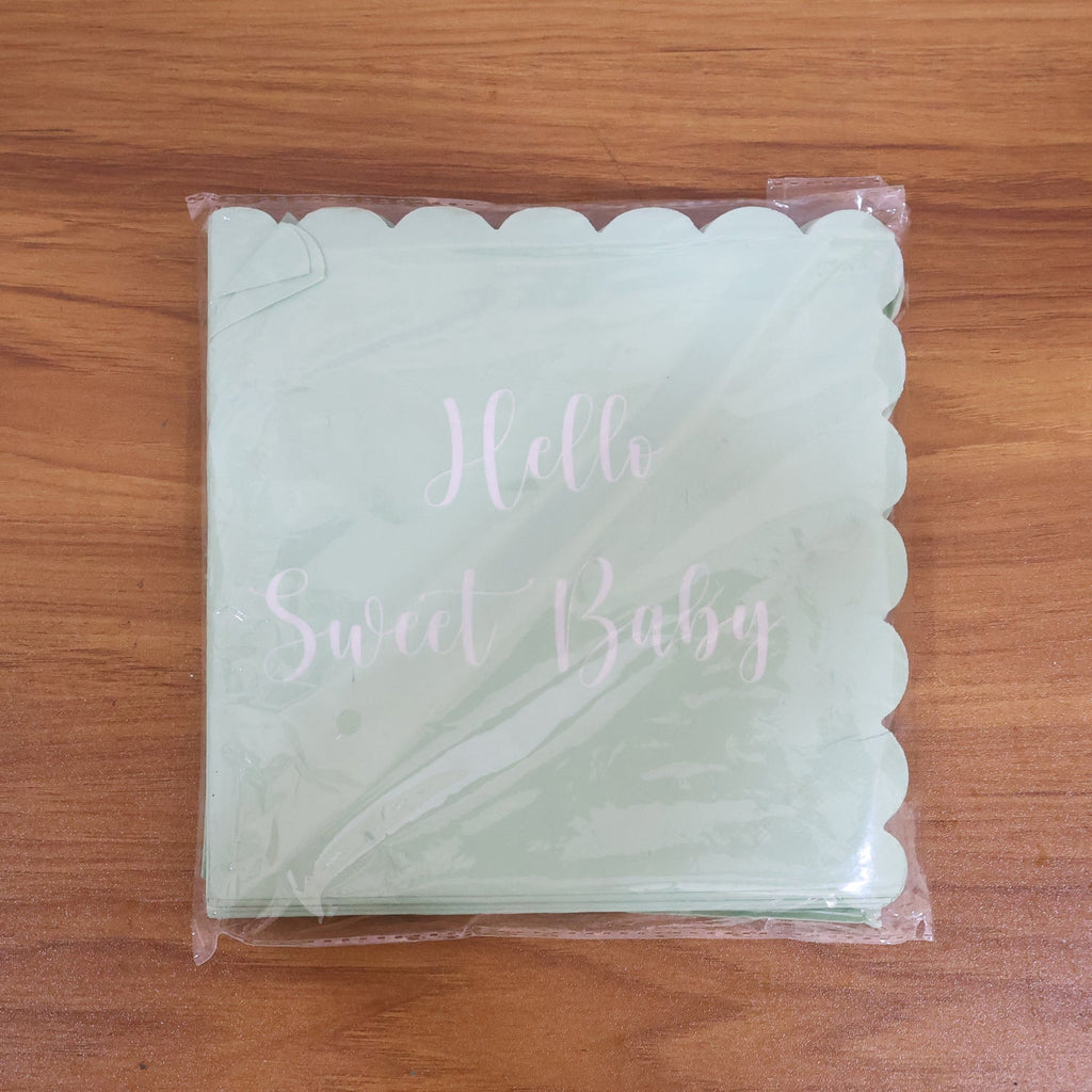 A stack of mint green scalloped napkins with "Hello Sweet Baby" in white script, sealed in clear plastic packaging.