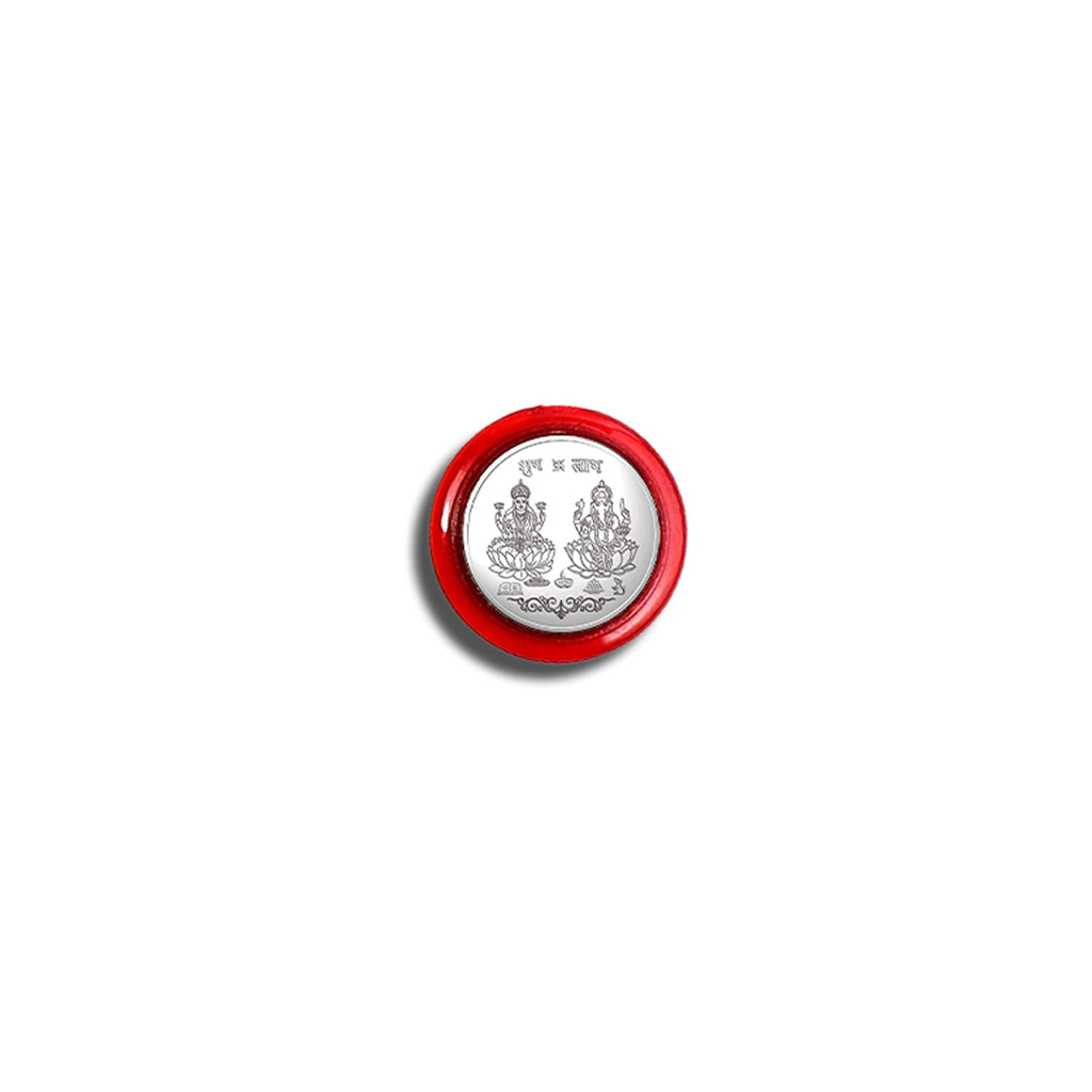 A single silver coin featuring Lakshmi and Ganesha in a red protective case, centered on a white background.
