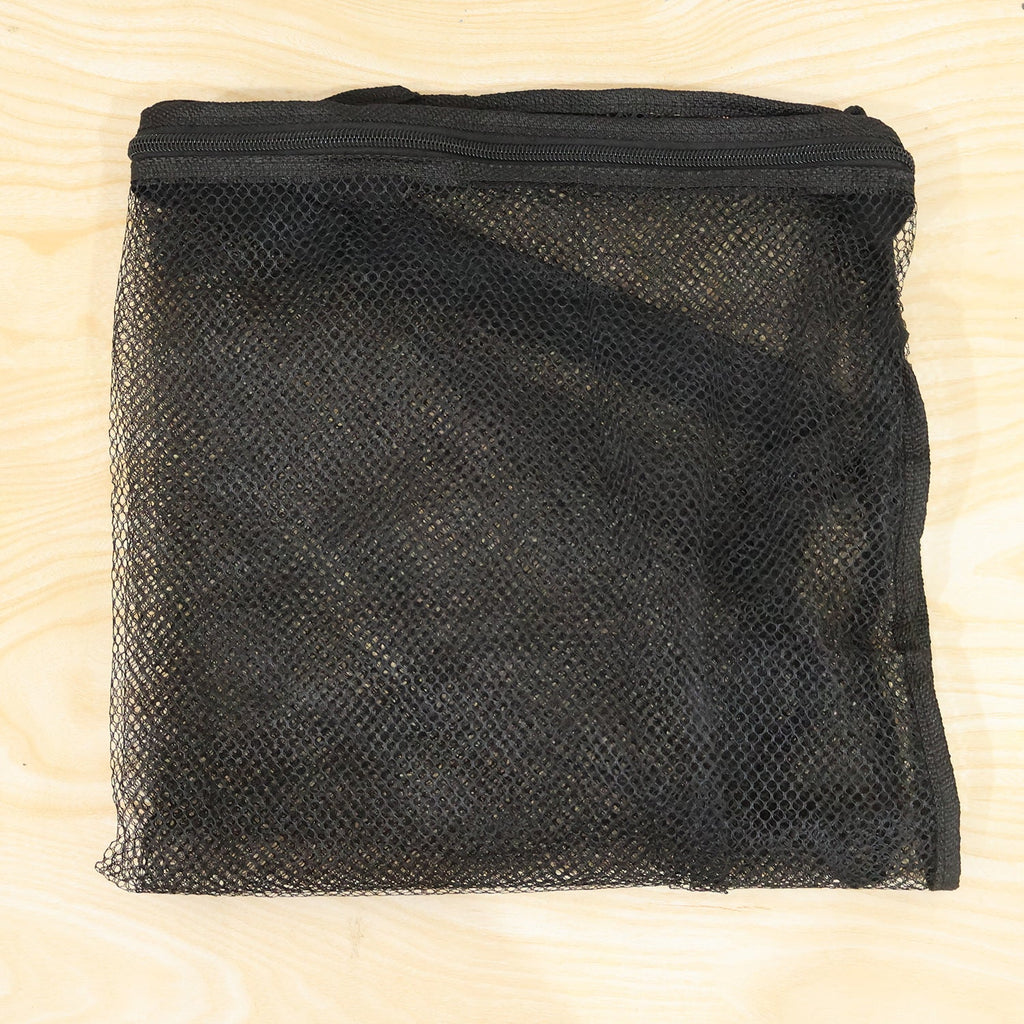 A folded black mesh zipper storage bag is laid flat on a light wood surface.