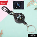 A black retractable keychain with a biohazard symbol on a light blue and pink background.