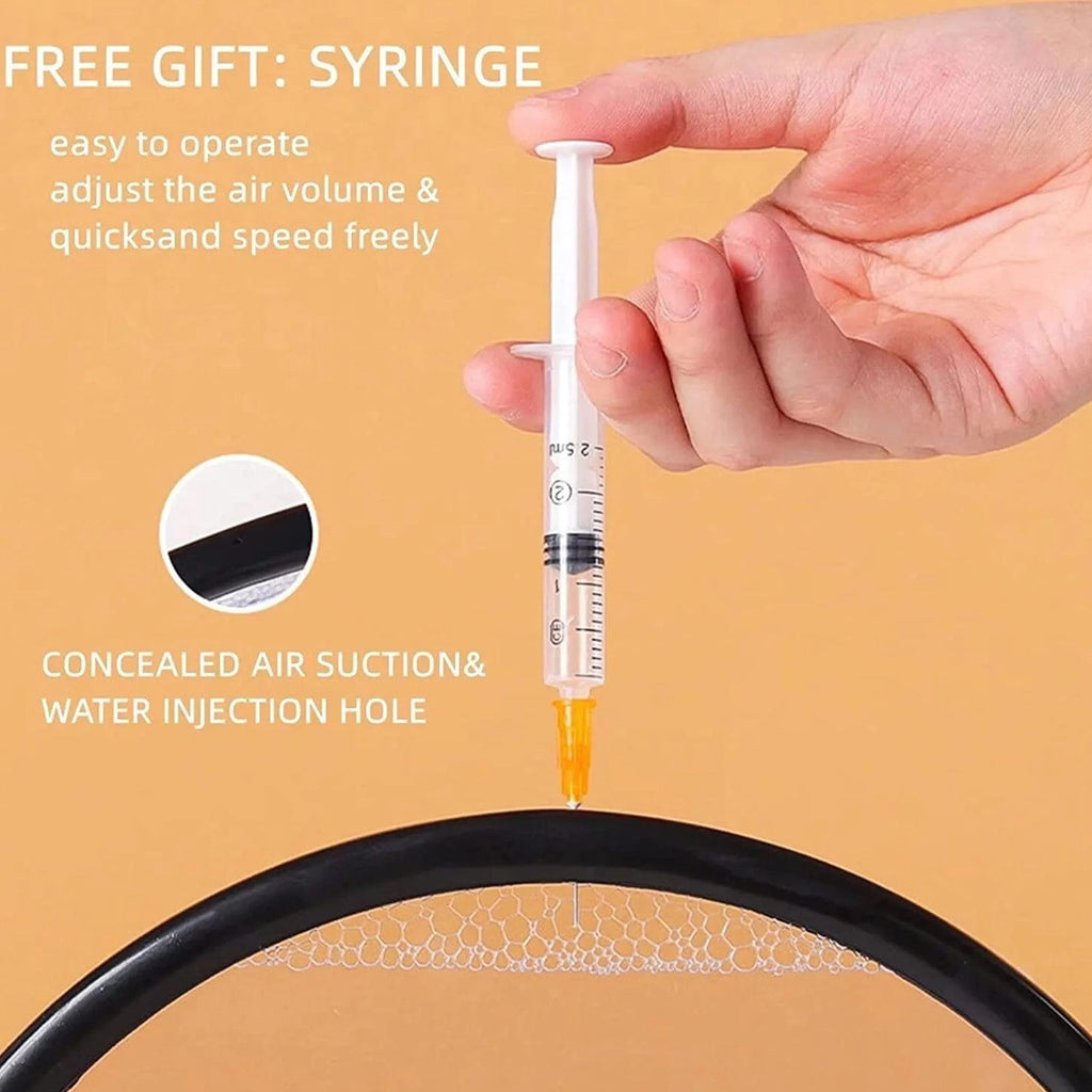 A hand holding a syringe, pointing towards the top edge of the black frame of the sand art, with text about adjusting air.