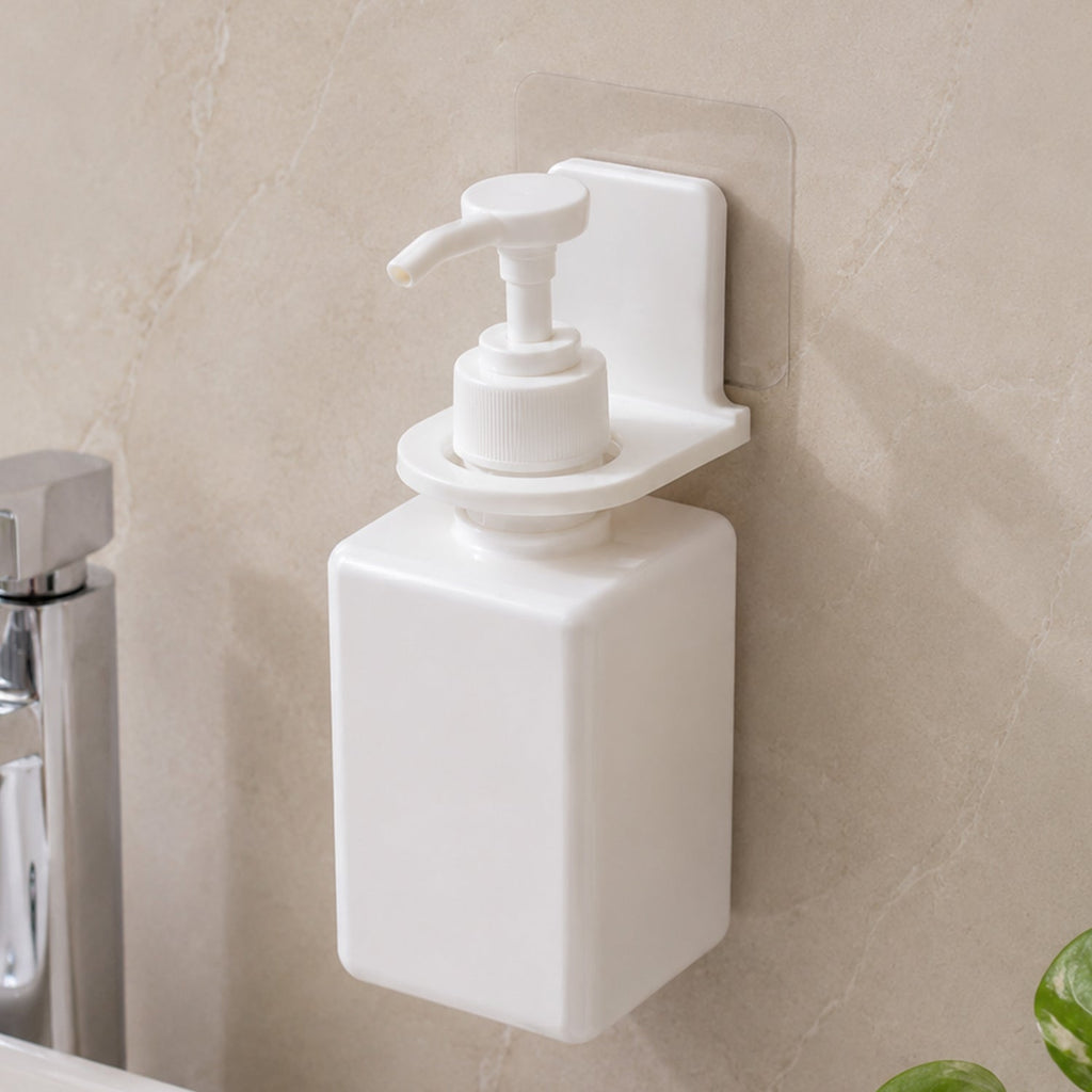 Two white plastic bottle holders on a gray tiled wall, one holding a loofah and the other a white pump bottle.