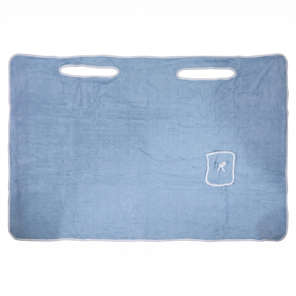 Flat lay of a light blue rectangular bath towel with white trim, two armholes, and a small pocket with an R monogram.
