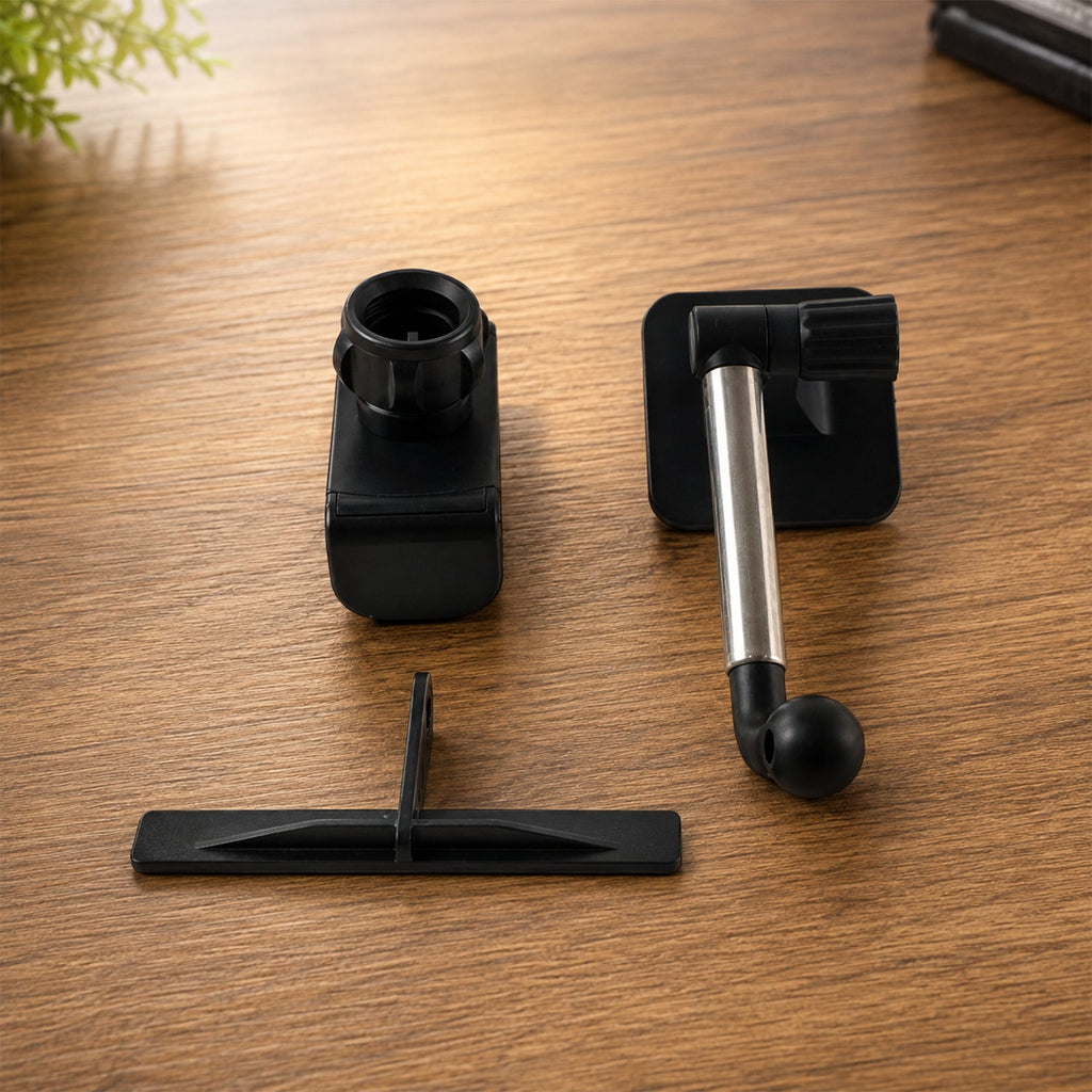 Disassembled black and silver car phone holder components on a wooden surface.