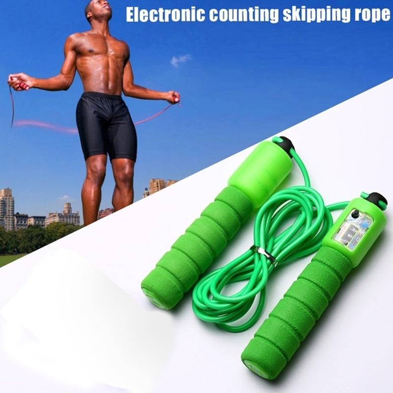 A man jumps rope outdoors under a blue sky, with a green electronic counting skipping rope in the foreground.