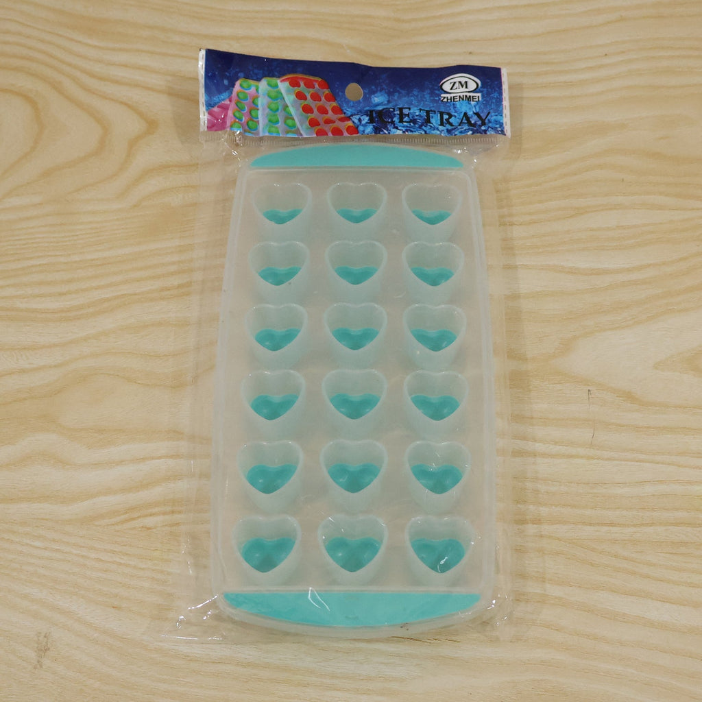 A clear and teal heart-shaped ice cube tray is sealed in plastic packaging with a colorful label, resting on a wooden