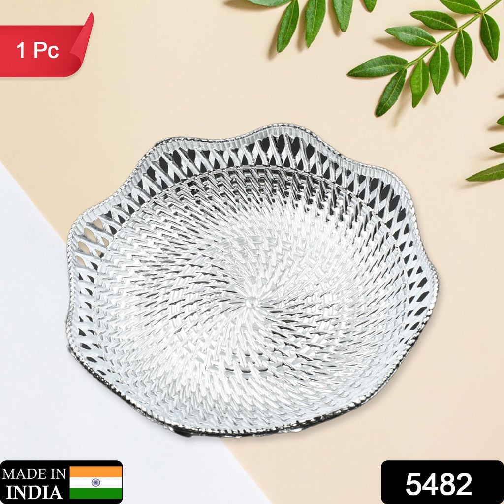 A silver plastic scalloped serving bowl with a textured bottom sits on a two-toned beige and white surface with – view 2
