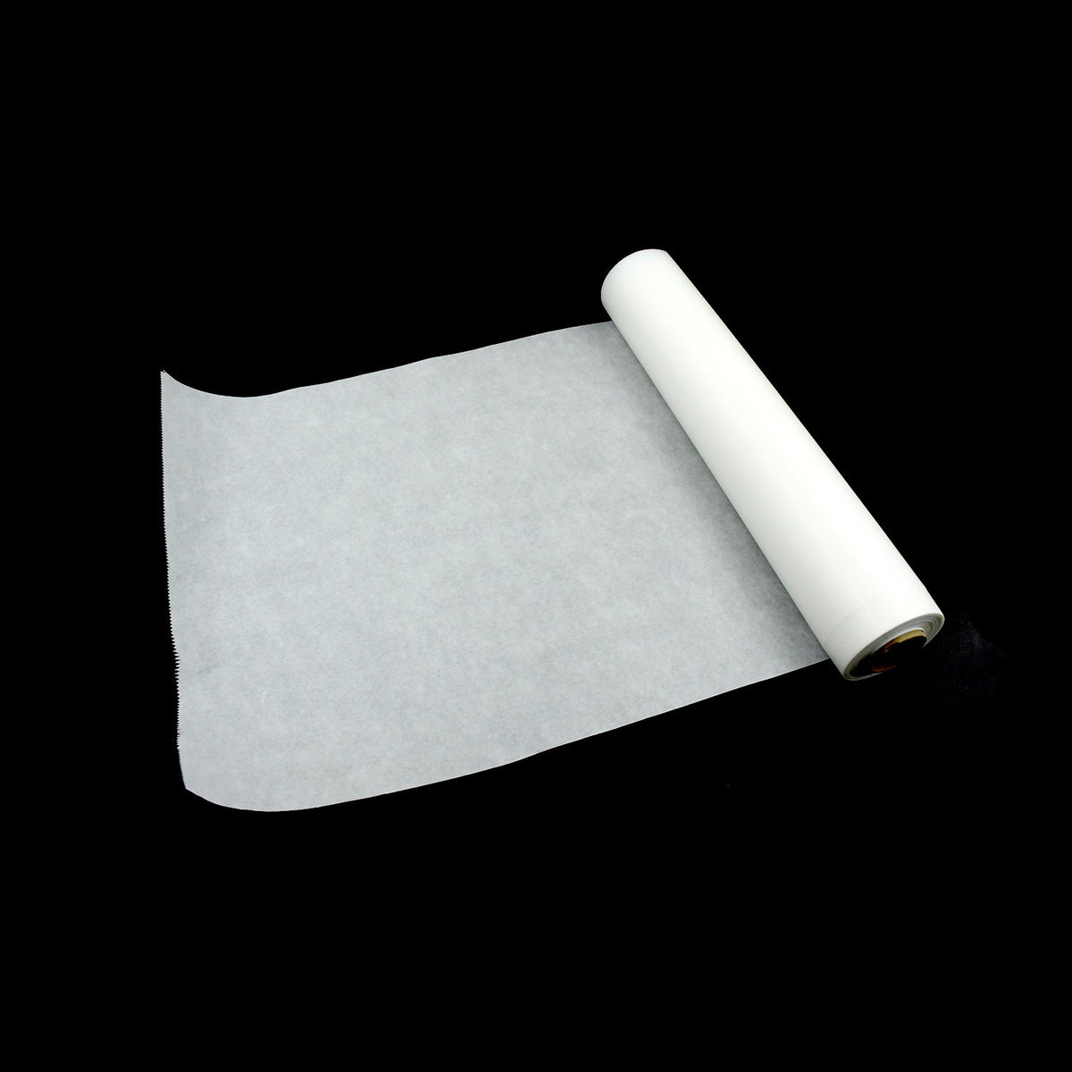 A roll of white non-stick baking paper unrolled slightly on a plain black background.