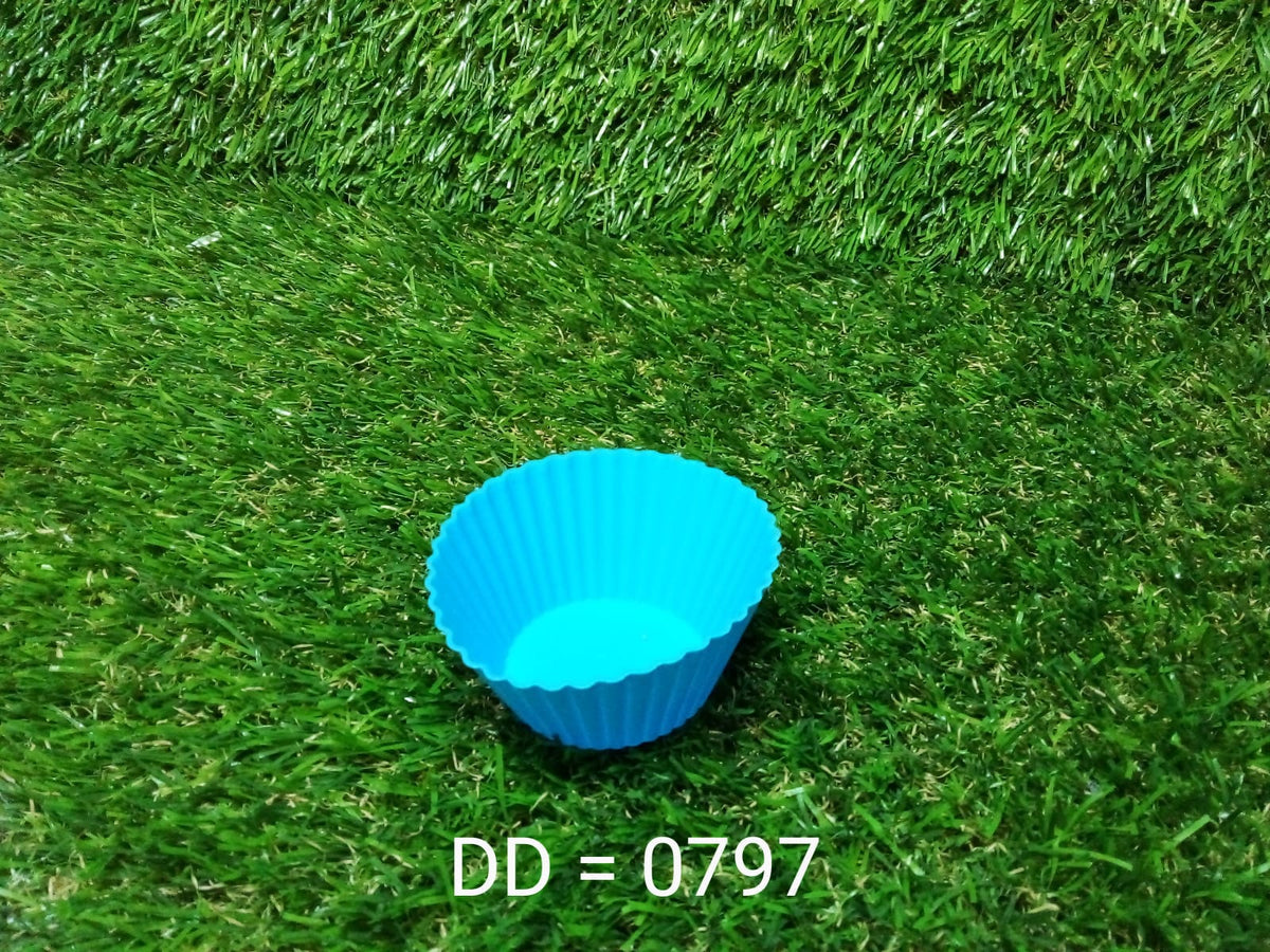 A single blue silicone cupcake mold rests on a vibrant green artificial grass surface with text "DD = 0797".