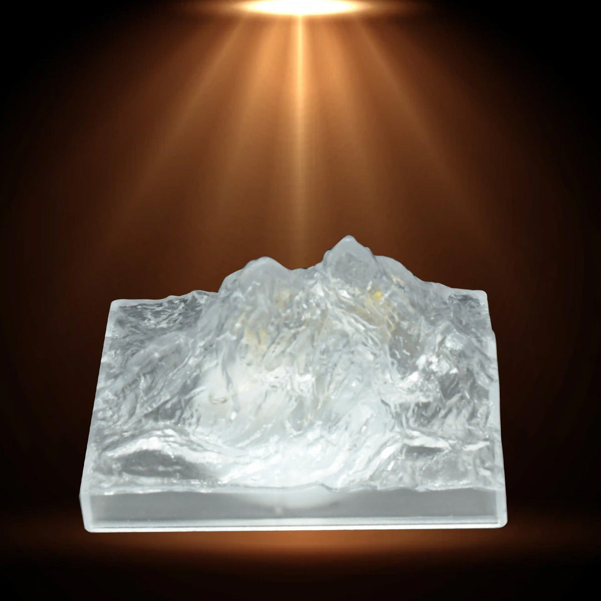 A clear, textured iceberg-shaped LED light glows with a warm light from above on a dark brown background.