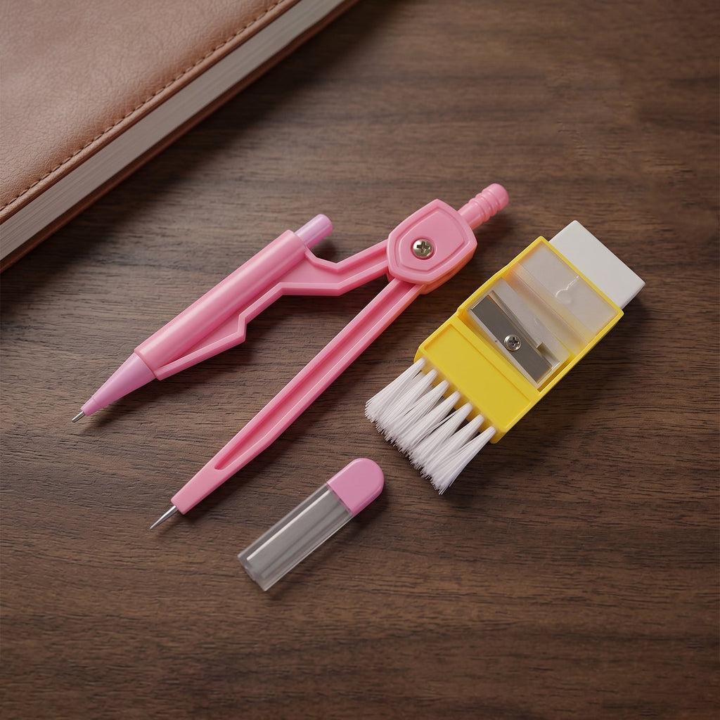 A pink compass, yellow eraser with brush, and lead refills neatly arranged on a dark wooden surface next to a brown notebook.