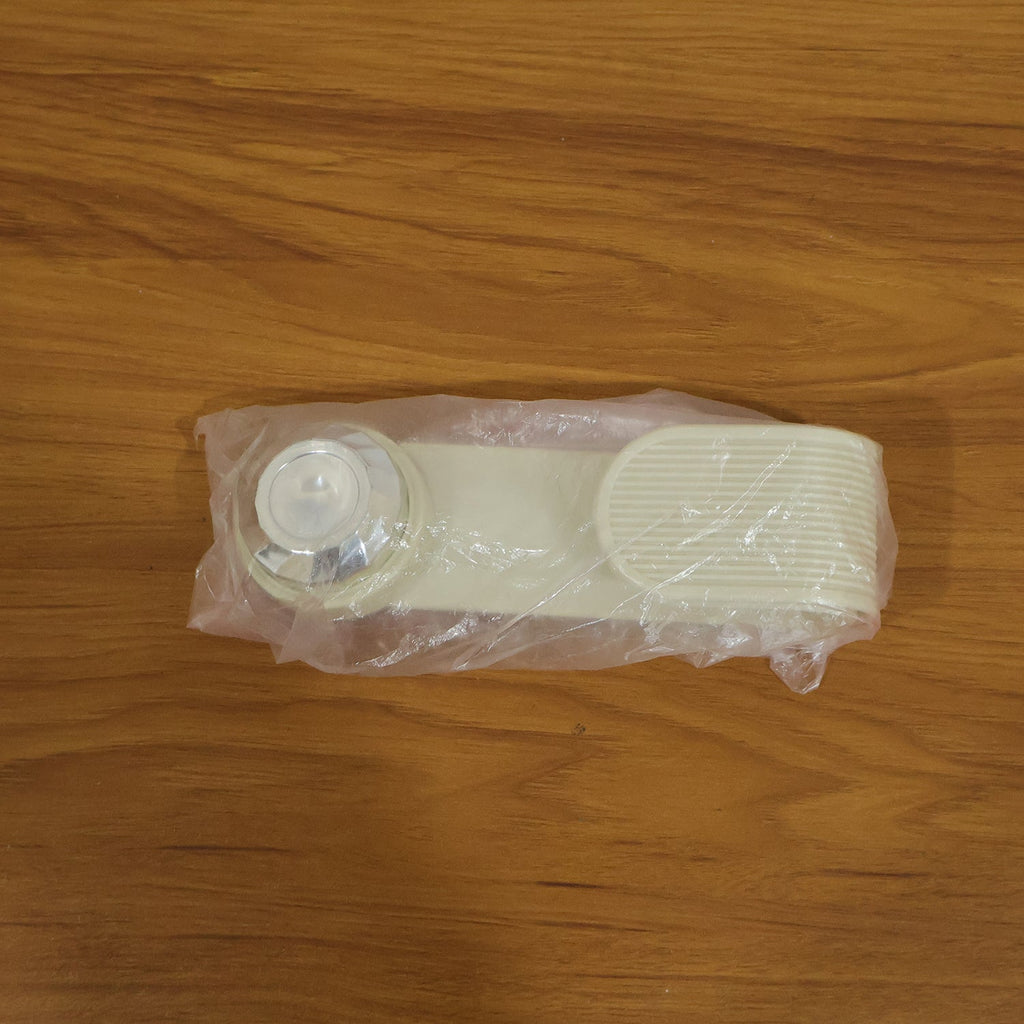 A cream-colored pot lid holder, folded into a straight shape, is sealed in clear plastic packaging on a wooden surface.