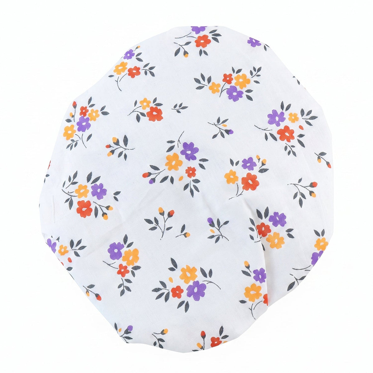 Flat lay of a round white fabric cover with scattered orange, purple, and red flowers.