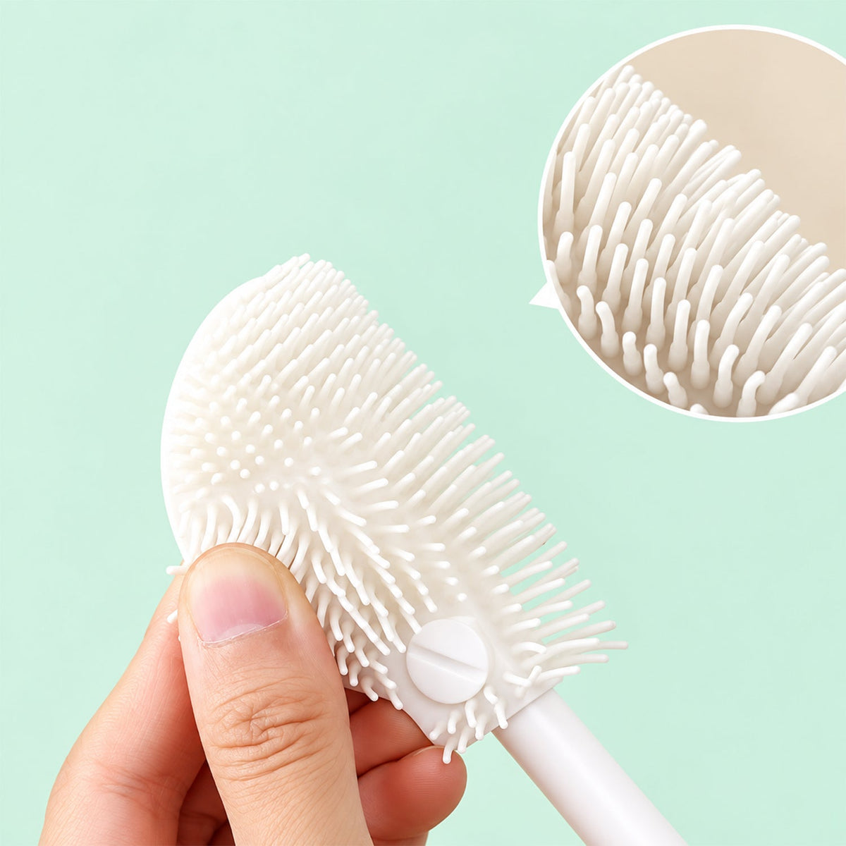 A hand holds the flexible white silicone brush head, with a magnified view of its soft bristles.
