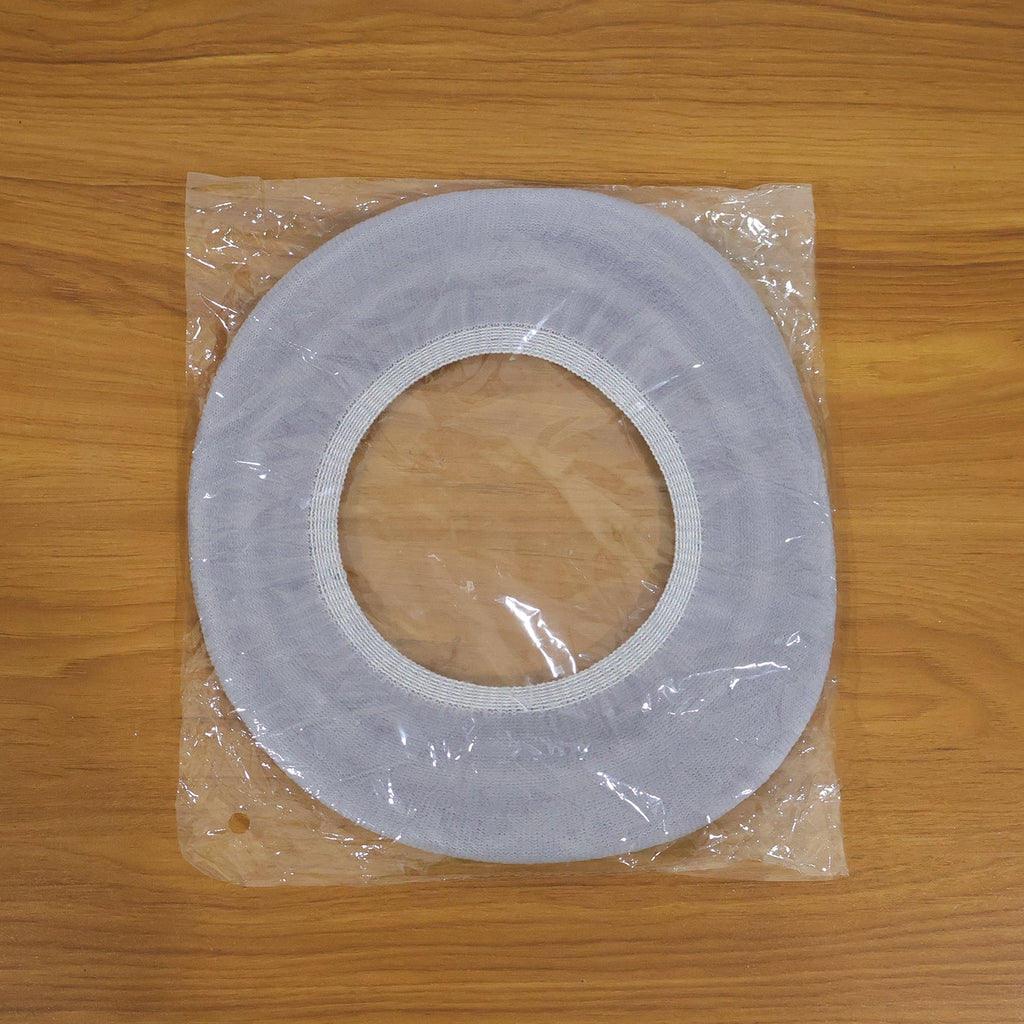 A light grey elastic toilet seat cover sealed in clear plastic packaging on a wooden surface.